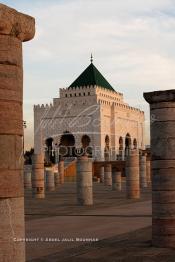 Image du Maroc Professionnelle de  Le tombeau du plus populaire des sultans du Maroc, Mohammed V, père de l’indépendance repose ici dans cette  demeure bâtie en marbre blanc et couronnée par un toit pyramidale orna de tuiles vertes, symbole de la royauté. Sa construction a nécessita une dizaine d’année, au premier plan  les colonnes de l’esplanade de la Mosquée Hassan à Rabat, Jeudi 1er Mars 2007. (Photo / Abdeljalil Bounhar)
